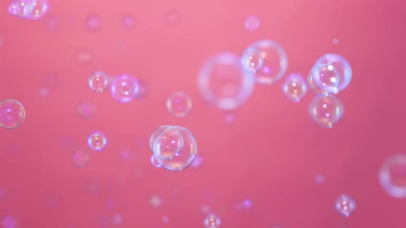 Beautiful Colored Soap Bubbles Fly Indoors on a Pink Background