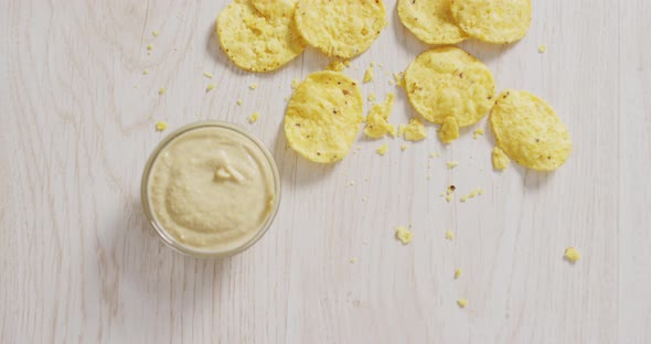 Video of crisps and cheese dip on a wooden surface