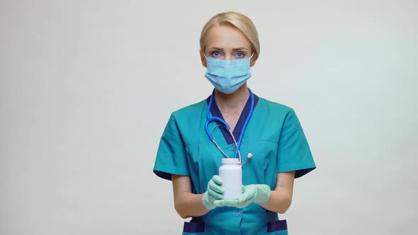 Medical Doctor Nurse Woman Wearing Protective Mask - Holding Can of Pills or Vitamins