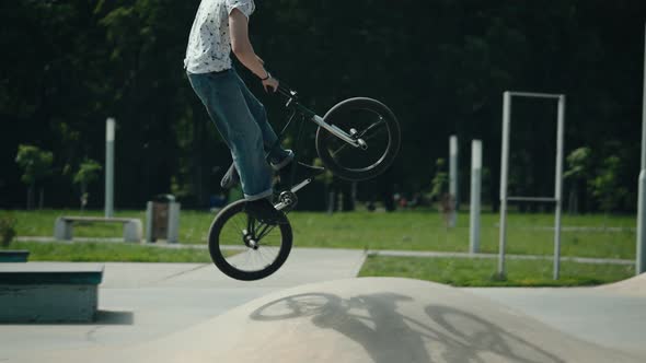 BMX Cyclist Extreme in the City Park Performs Dangerous Jumping Stunts