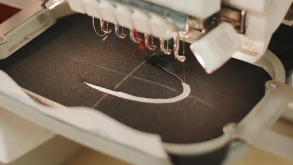 The automatic embroidery machine is working at high speed. Close-up