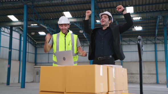 Two Factory Worker Celebrate Success Together in the Factory