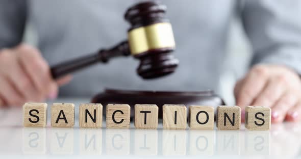 Gavel of Judge and Text of Sanction in Courtroom Closeup