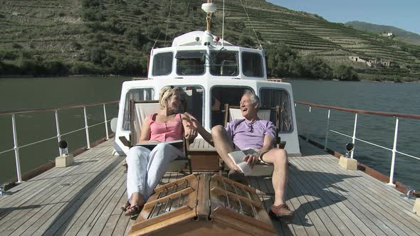 Senior couple sitting on deckchairs on a boat