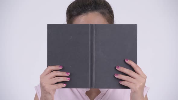 Face of Young Beautiful Asian Businesswoman Covering Face with Book