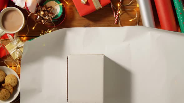 Hands Wrapping Christmas Gift Into Paper at Home