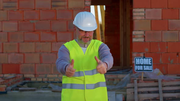 Engineer Architect Looking Approvingly at Camera Showing Thumbs Up Recommending Buying a House