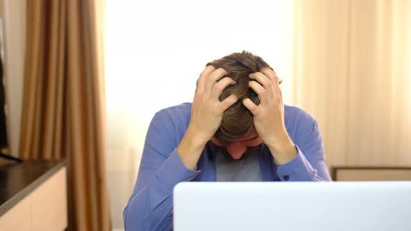 Young Stressed Handsome Man Working in Living Room Shouting at Laptop Screen and Being Angry