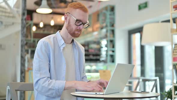 No Finger Gesture By Redhead Man with Laptop in Cafe