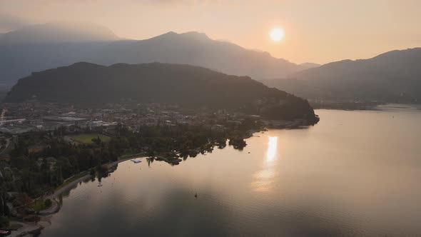 Cinematic Aerial View of Idyllic Sunrise Above Garda Lake and Riva De Garda City on Summer Morning