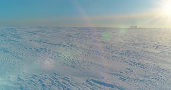 Aerial View of Cold Winter Landscape Arctic Field Trees Covered with Frost Snow Ice River and Sun