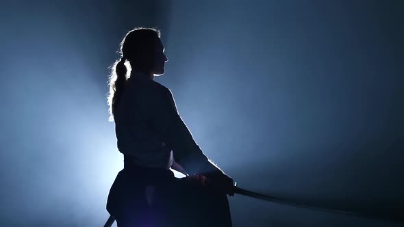 Silhouette of the Master Aikido Training with Japanese Sword Katana in Martial Arts School. Healthy