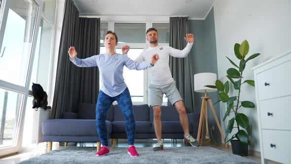 Caucasian Couple is Doing Cardio Exercise at Home in Cozy Bright Room Slow Motion