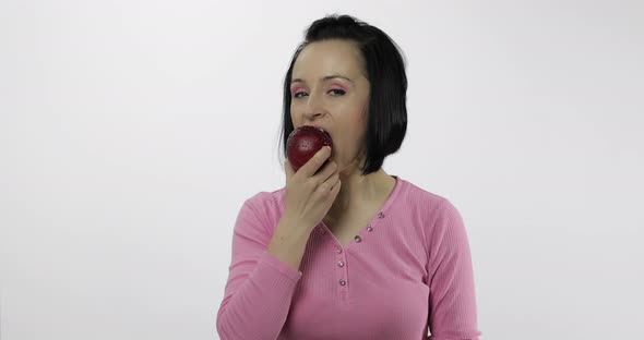 Young Woman Eating Apple and Says Yum. Girl Takes First Bite and Say Wanna Bite