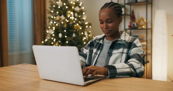 Africanlooking Girl Playing Online Game with Friend on Laptop alt