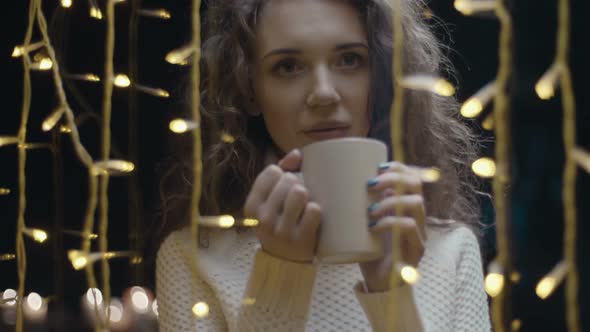 Daydreaming Young Woman Looking through Window