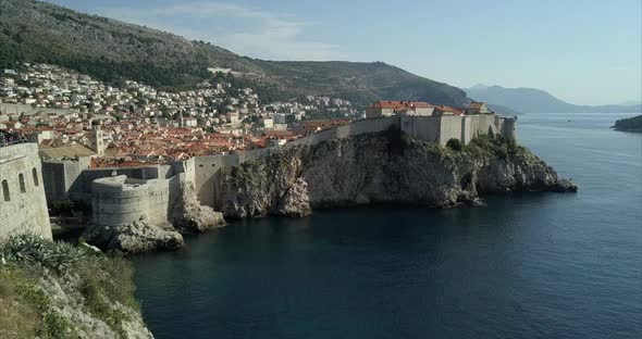 Aerial shot of Dubrovnik Old Town. the camera passes close by Fort Lovrijenac, over the city walls a