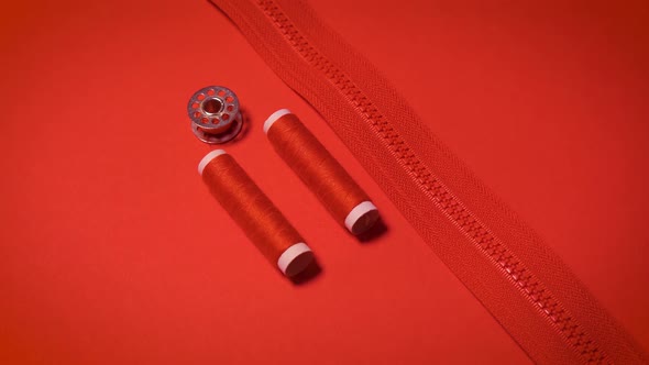 Threads and Zipper on a Red Minimalistic Background