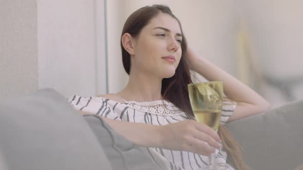 Young adult relaxing with wine at home