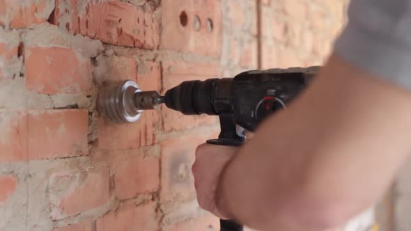 A construction worker works with a puncher close up.