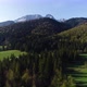 Aerial view of green hills and mountains covered with snow in summer or spring.  - VideoHive Item for Sale