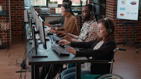 Young Woman in Wheelchair Helping Clients at Call Center