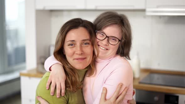 Sweet Down Syndrome Daughter Smiling with Her Mom