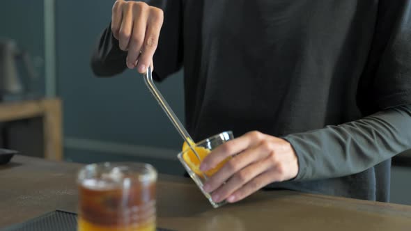 4K Asian woman barista making iced black coffee with orange juice serving to customer