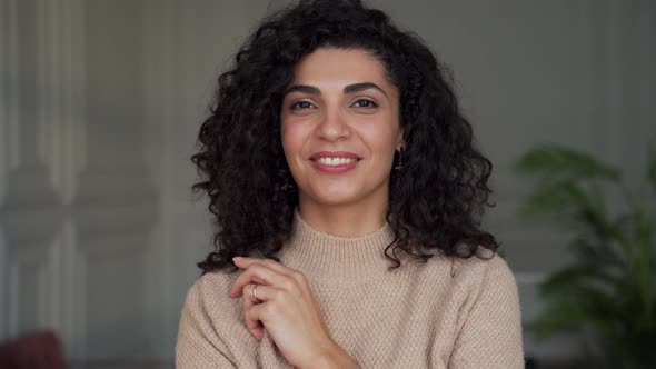 Portrait of a Beautiful Curlyhaired Woman with Black Hair Smiling at the Camera