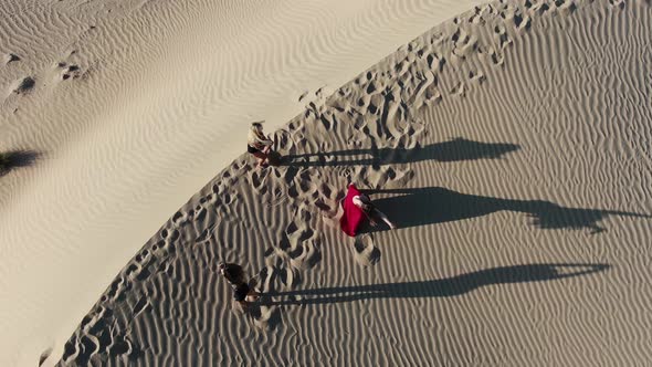 Top View on Three Young Women Dancing in the Desert Sand Dune Rub Al Khali