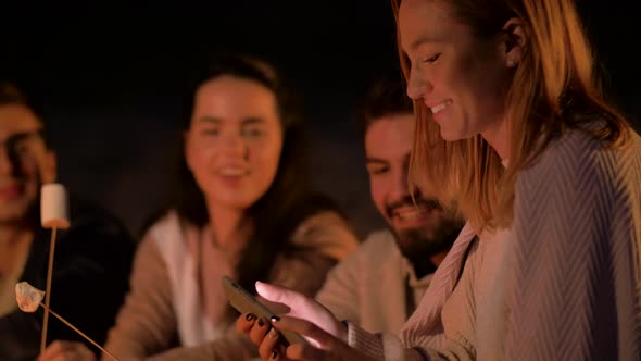 Friends Taking Selfie By Smartphone at Night Fire