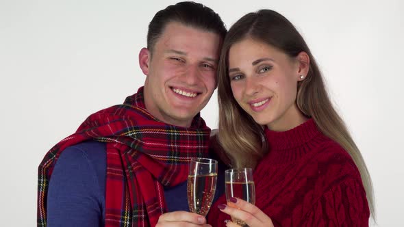 Young Couple Smiling, Toasting with Their Champagne Glasses To the Camera