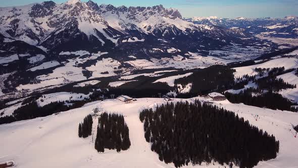 Snowy mountains in low clouds and blue sky at sunset in winter. Panoramic landscape with beautiful s