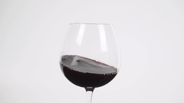 Swirling red wine in burgundy glass