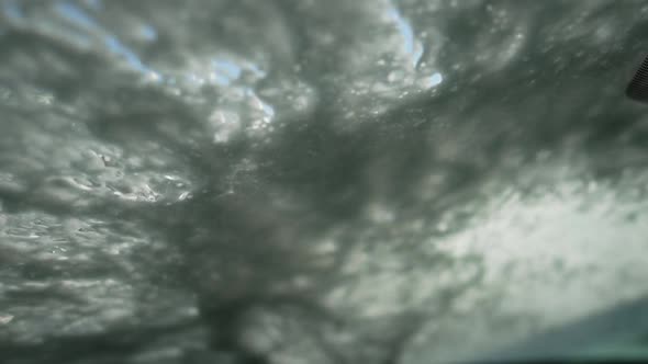 Car Wash Shampoo Covering Windshield in Slow Motion Bottom View
