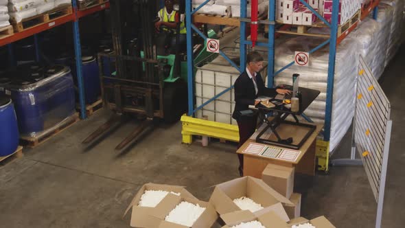 Female warehouse manager working standing at a desk 4k