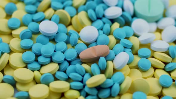 Multi-colored Pills Fall on a Scattering of Yellow and Blue Drugs. Slow Motion
