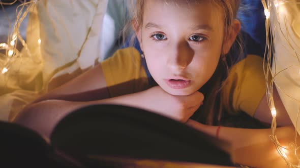 Family Bedtime Pretty Girl Reading Book in a Tent House at Night