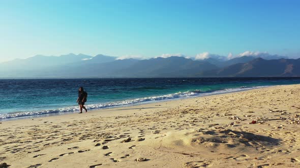 Pretty fun woman relaxing in the sun at the beach on sunny blue and white sand background 4K