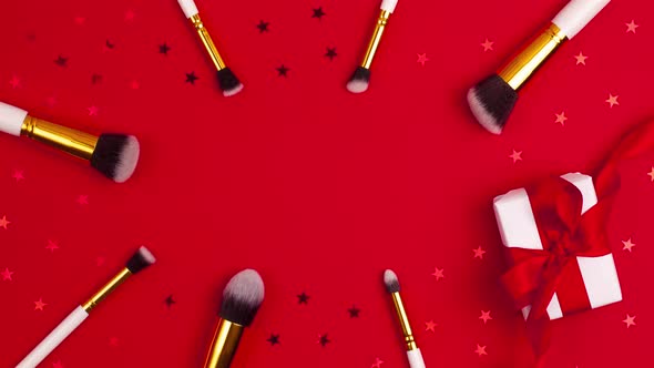 Stop motion animation of top view of gold colored  cosmetics brushes set for makeup, white present alt