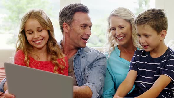 Happy family using laptop in living room