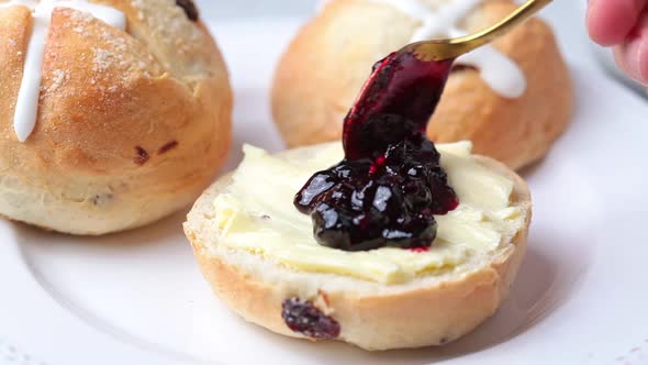 Hands Cooking Easter Cross Buns with Raisins Butter and Jam