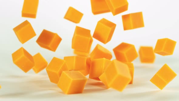Super Slow Motion Shot of Cheddar Cheese Cubes Falling on White Background at 1000 Fps.