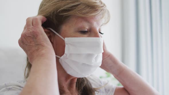 Senior woman wearing face mask at home