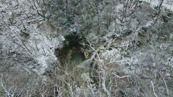 Waterfall Flowing From White Rocks Into a Lake in the Forest