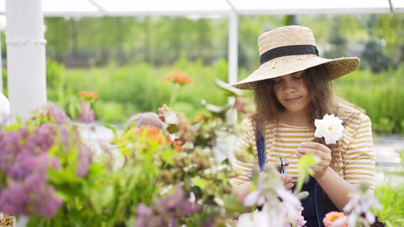 Lady in Hat Chooses Flowers From Vases at Masterclass