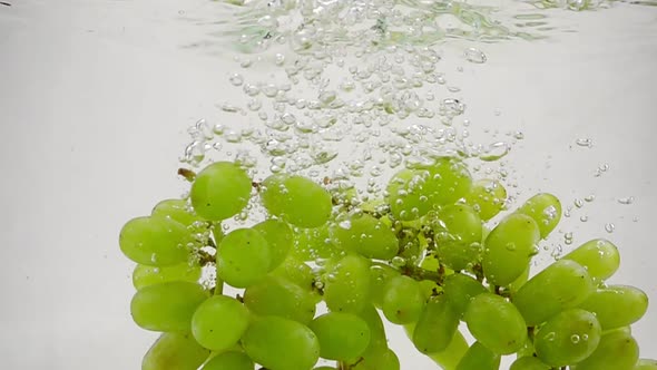 Slow Motion Video of Green Grapes. Bunch of Grapes Are Immersed in Water with Bubbles.