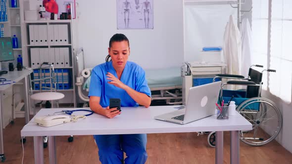 Therapist Assistant Holding Smartphone Talking to Patient
