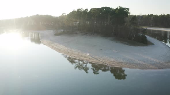 Aerial view of a woman walking along the shoreline, Netherlands.