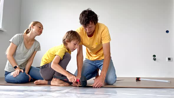 A Family of Mother Father and Son Install Laminate on the Floor in Their Apartment